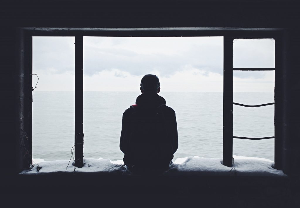 man alone looking out the window